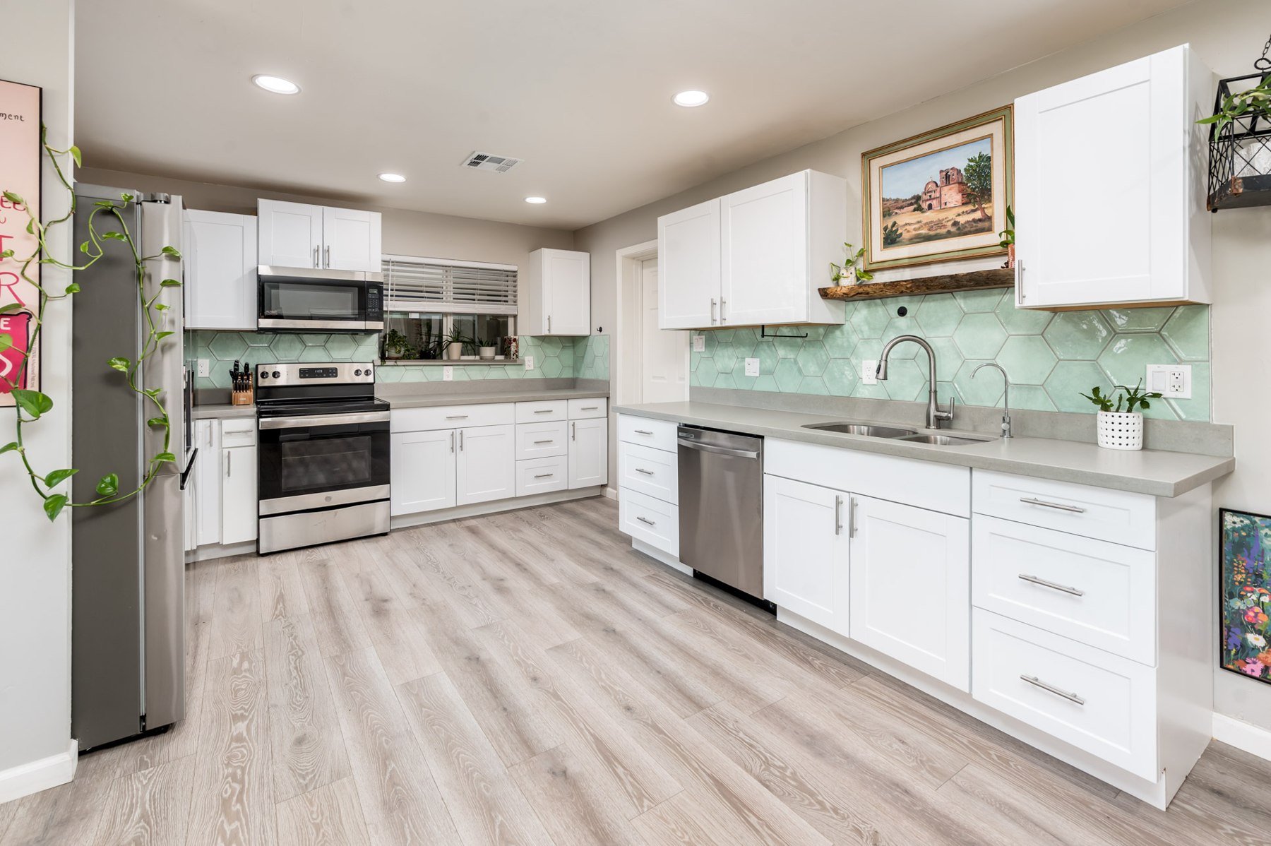 Kitchen with white shaker cabinets and gray quartz counters
